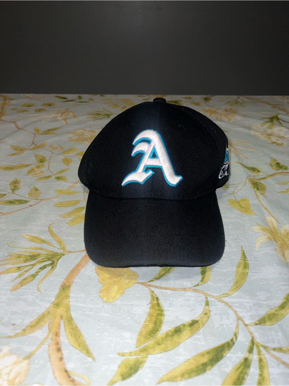 Black Baseball Cap with Teal-Outlined 'A' Logo